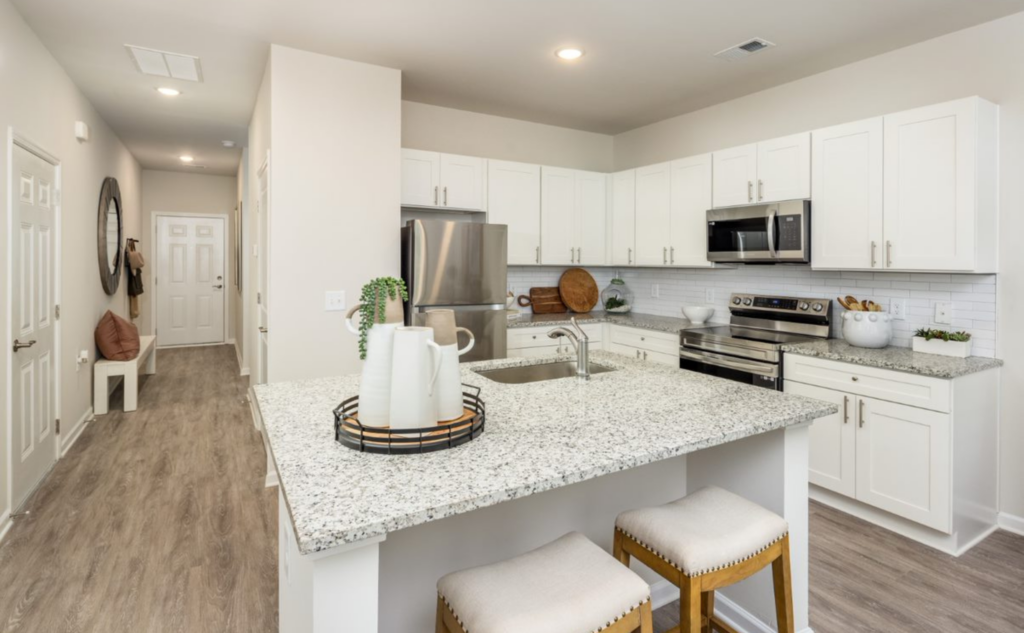 The Cottages at New Hampstead model home kitchen with granite countertops, white cabinetry and spacious kitchen island